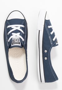 Námořnické modré plátěné tenisky s bílými šňůrkami a špičkami, vybavené gumovou podrážkou, bočními perforacemi a texturovanou vnitřní podešví s logem.