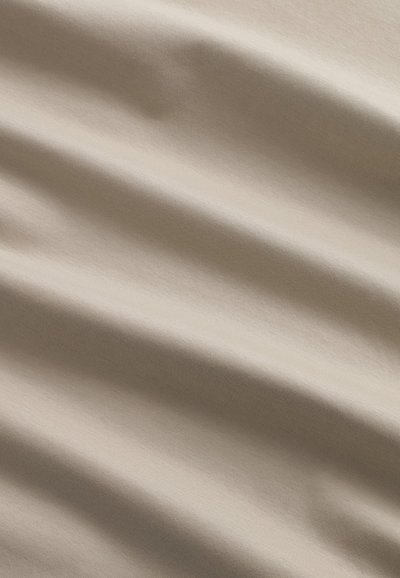 Tessuto beige con una superficie liscia e una leggera lucentezza, caratterizzato da pieghe e grinze morbide, che creano un aspetto morbido e cadente.