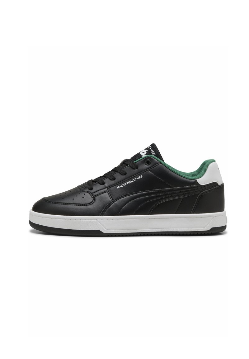 Black leather sneaker featuring a white sole, green accents on the heel, and perforated detail on the vamp. "Porsche" logo on the side.