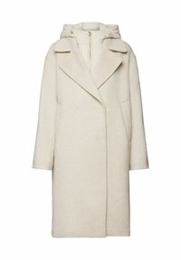 Abrigo de color beige claro hecho de una tela suave, con capucha, grandes solapas y bolsillos laterales. El diseño es de corte oversized con forma recta.