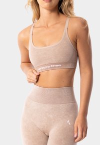 Gaišbeidzīgu sporta krūšturis ar mīkstu tekstūru un platām elastīgām siksnām, uz kurām ir balta marka "carpatree". Saderīgas augsta vidukļa legingu komplekts.