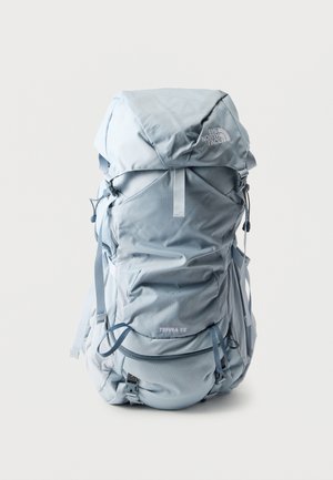 Jasnoniebieski plecak turystyczny North Face Terra 55 z wieloma paskami i zamykanymi na zamek przegrodami, na białym tle.