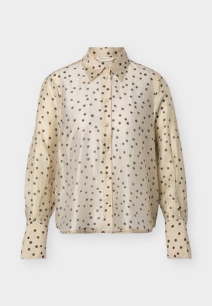 Bézs, hosszú ujjú, gombos blúz fekete pöttyökkel, hegyes gallérral és gombos mandzsettákkal.