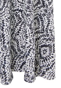 Rochie cu model alb și negru, cu spirale abstracte și forme geometrice, realizată dintr-un material ușor, cu o textură fină.
