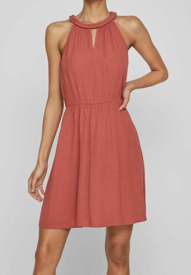 Rostfarbendes Kleid mit Neckholder und strukturiertem Stoff. Verfügt über eine Schlüsselöffnung an der Vorderseite und einen elastischen Bund für eine optimale Passform.