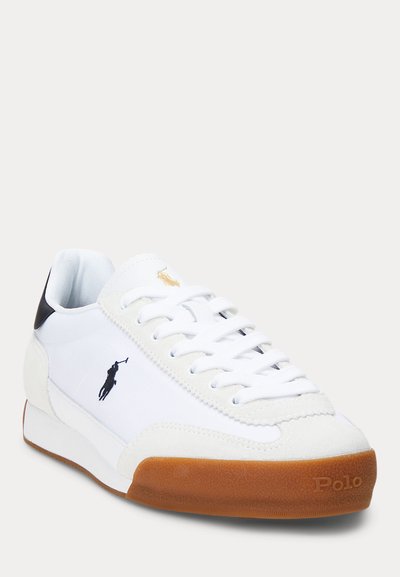 Λευκό αθλητικό παπούτσι με κορδόνια και σόλα από καουτσούκ, μαύρο ταμπελάκι στη φτέρνα, κεντητό λογότυπο παίκτη πόλο στο πλάι και χρυσό λογότυπο στη γλώσσα.