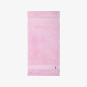 Pink terry cloth bath towel with soft texture, featuring two horizontal stripes and a blue logo embroidered at the bottom corner.