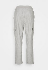 Jasnoszare spodnie cargo o luźnym kroju, z elastycznym pasem i kieszeniami po bokach. Materiał wydaje się miękki z teksturowanym wykończeniem.