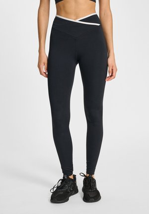 Sorte leggings med høj talje, der har en hvid accentstribe og et tætsiddende design. Lavet af strækbart stof, som giver en glat tekstur.