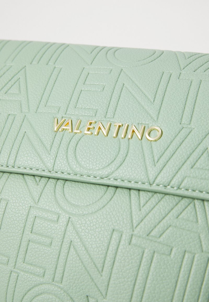 Borsa in pelle testurizzata verde menta con logo "Valentino" impresso e hardware dorato. Superficie liscia con motivo di caratteri pronunciati.