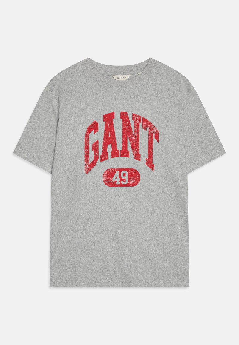 Pilkas medvilnės marškinėliai su nusidėvėjusiu raudonu spaudiniu "GANT" ir "49" ryškiu šriftu. Apvali iškirptė ir trumpomis rankovėmis. Minkšta tekstūra.