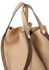 Beigefarbene Ledertasche mit strukturierter Oberfläche, ausgestattet mit zwei glatten braunen Griffen und goldfarbenen Beschlägen.