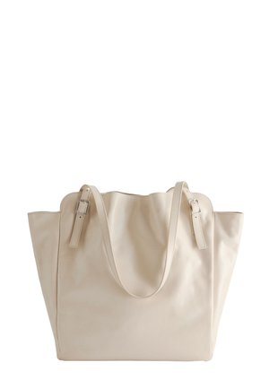 Beige Ledertasche mit gewellten Oberkanten, zwei verstellbaren Schulterriemen mit silbernen Schnallen und einer leicht schlaffen Form.