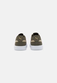 Sneakers verde oliva con suola bianca e dettagli dorati. Presentano un materiale morbido, colletto imbottito e un logo sul tallone. Design elegante.