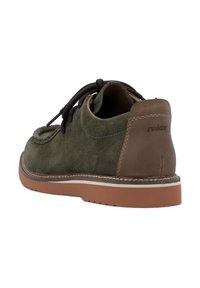Zapato de ante verde con tacón de cuero marrón y costuras en crema. Presenta cordones redondos y una suela de goma texturizada. En la parte trasera dice "rieker."