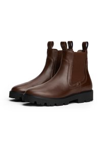 Braune Leder Chelsea-Stiefel mit elastischen Seiteneinsatz, Zugschlaufen und einer klobigen schwarzen Gummisohle. Glatte Textur mit kontrastierenden Steppdetails.