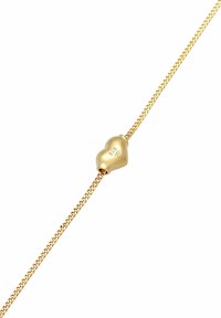 Guldtonad armband med en slank, hjärtformad berlock med ingraverad "925"-markering, placerad på en fin vävd kedja.