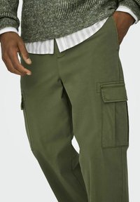 Olijfgroene cargo shorts met zijzakken, een ontspannen pasvorm en duurzame stof. De tailleband is discreet en ontworpen voor comfort.