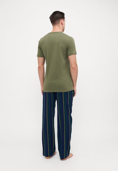 Olive green short-sleeve t-shirt paired with navy blue striped pants featuring yellow and green lines; casual, loose-fitting design.