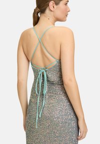 Glitzerndes Kleid mit dünnen, verstellbaren aqua-farbenen Trägern. Rückseite mit überkreuztem Design und gebundenem Verschluss. Funkelnde Textur aus mehrfarbigen Pailletten.