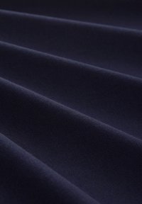 Tessuto blu navy con una trama texturizzata, caratterizzato da drappeggi orizzontali e una leggera profondità. Superficie liscia con una finitura morbida.