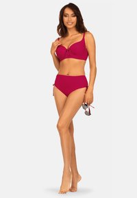 Magenta bikini w składzie, który zawiera top z formowanymi miseczkami, ozdobiony centralną kokardą i regulowanymi ramiączkami, w komplecie z majtkami typu high-waisted z bocznymi troczkami.