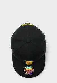 Musta baseball-lippis, jonka etupuolella on kohotettu keltainen kirjain "B". Sisältää holografisen tarran, jossa lukee "Original Fit" ja bränditiedot.