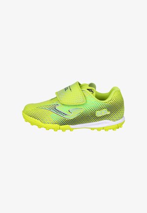 Taco de color verde amarillento brillante con patrón de puntos negros, cierre de velcro y suela texturizada diseñada para césped artificial o turf.