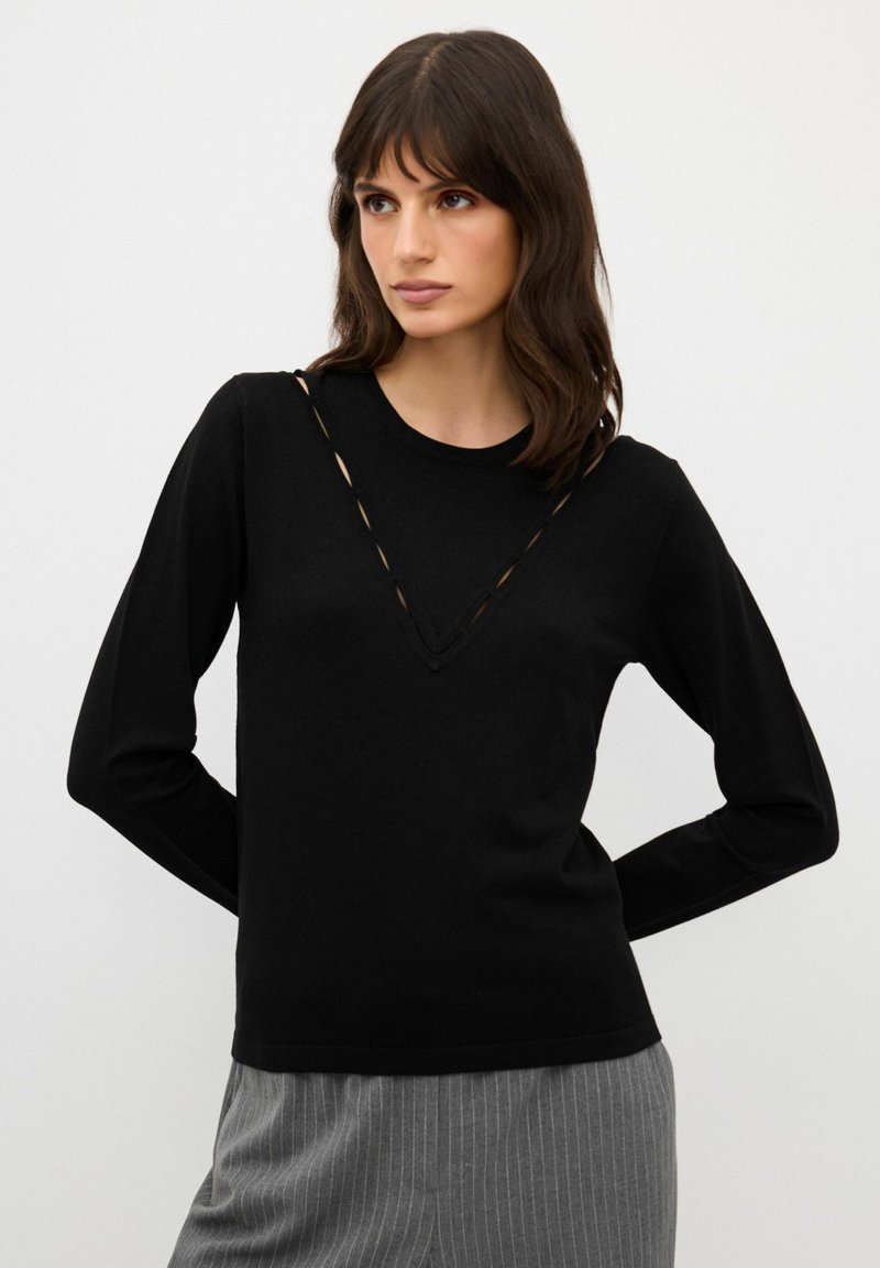 Maglione nero a maniche lunghe con scollo arrotondato e ritagli a forma di V sulla parte anteriore. Tessuto morbido e design aderente. Stile minimalista.