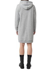 Szara sukienka dresowa z kapturem, o luźnym kroju, z prążkowanymi mankietami i długością do kolan. W połączeniu z czarnymi kozaczkami za kolano.