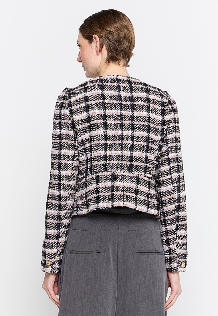 Chaqueta de tweed a cuadros en negro, rosa y blanco, con un diseño corto, mangas largas y acentos de botones dorados en los puños.