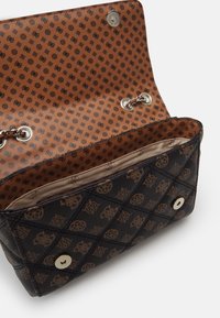 Czarna torebka z wzorem, wykonana z teksturowanej skóry, z brązowym wnętrzem w wzory, srebrnymi elementami metalowymi i zapięciem na guzik.