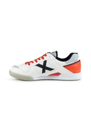 Baskets blanches avec lacets rouges, logo X noir sur le côté, patch rouge au talon et semelle translucide, vues de l'extérieur.