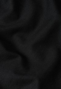 Tessuto nero con una superficie liscia, che presenta pieghe morbide e una leggera lucentezza, caratterizzato da un motivo a tela semplice senza decorazioni visibili.