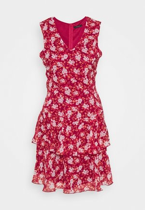 Robe fleurie rouge avec un décolleté en V, sans manches, à volants superposés au bas, ornée de fleurs blanches et roses sur un fond uni.