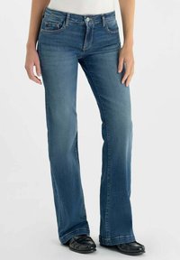 Jean évasé en denim bleu avec un lavage moyen, présentant un design à cinq poches, des coutures contrastantes et une fermeture par bouton à la taille.