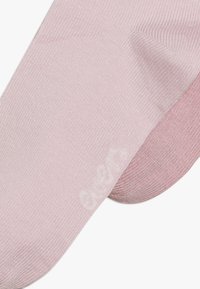 Helle rosa Socken mit strukturiertem Strick, die an der Spitze einen leicht dunkleren rosa Akzent aufweisen. Weiches Material, nahtloses Design für einen hohen Tragekomfort.