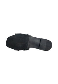 Suela de zapato de goma negra con superficie texturizada, que presenta ranuras para tracción y un diseño plano, sin detalles ni acentos adicionales.