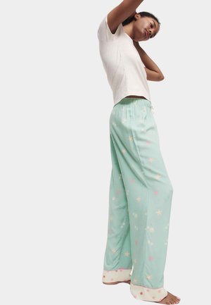 Mint green pajama pants with star and shell pattern, elastic waistband, wide legs, and contrasting light-colored cuffs.
