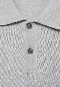 Hellgraues, strukturiertes Poloshirt mit einem Strickkragen und zwei dunkelgrauen Knöpfen an der Knopfleiste.