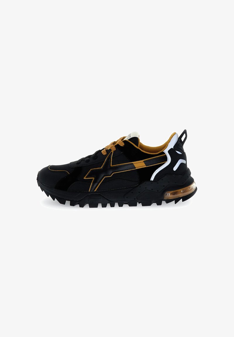 Sneaker atletiche nere con accenti oro e bianchi, caratterizzate da una tomaia testurizzata, suola in gomma spessa e ammortizzazione visibile nel tallone.