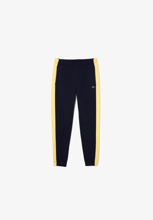 Námorně modré tepláky se žlutými bočními pruhy, elastickým páskem a malým vyšívaným logem na levém stehně.