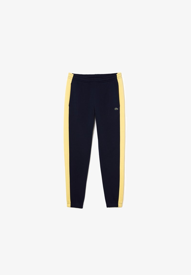 Marineblauwe trainingsbroek met gele zijstrepen, elastische tailleband en een klein geborduurd logo op de linker bovenbeen.