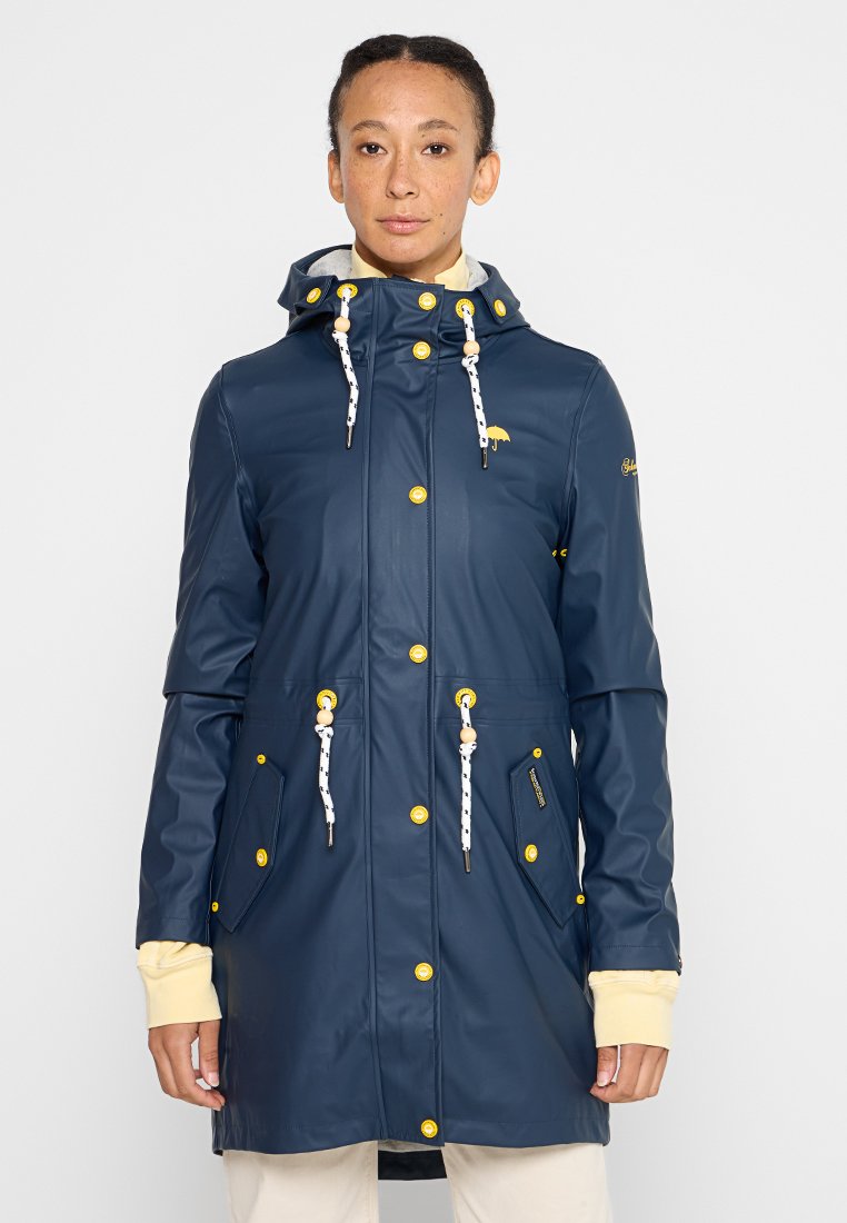 Giacca da pioggia impermeabile blu navy con cappuccio, accenti gialli, bottoni a pressione, cordino in vita e due tasche frontali. Texture liscia.