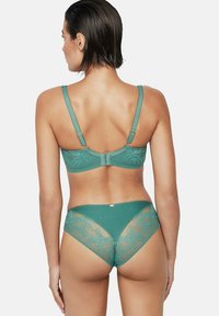Soutien-gorge en dentelle vert d'eau et culotte taille haute assortie. Présente des motifs floraux, des bretelles réglables et un fermoir à crochets au dos.