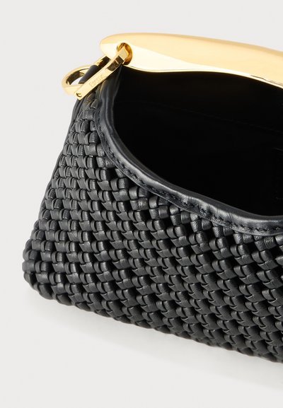 Μαύρο πλεκτό δερμάτινο τσαντάκι clutch με καμπυλωτό χρυσό μεταλλικό κούμπωμα και τζιπ, αποτυπωμένο εν μέρει ανοιχτό σε απλό φόντο.