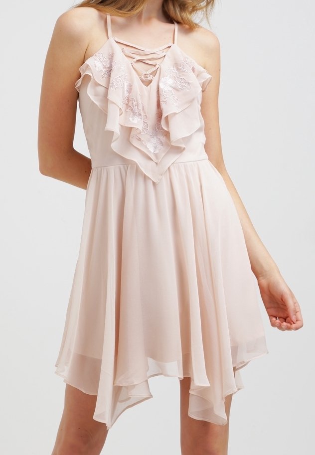 Světle růžové šaty s přiléhavým živůtkem, vrstveným volánem na výstřihu a nastavitelnými tenkými ramínky. Volánkový, asymetrický lem.