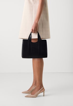 Czarna torebka typu tote z wytłaczanym wzorem krokodyla, z krótkimi uchwytami, prostokątnym kształtem, gładką teksturą, minimalistycznym designem i bez widocznych elementów metalowych.