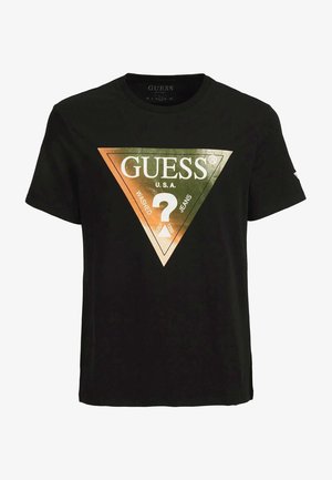 Camiseta negra de algodón con un logo de triángulo en oro y plata que incluye "GUESS U.S.A." y un signo de interrogación, mangas cortas y cuello redondo.