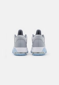 Zapatillas deportivas grises con parte superior texturizada, cuello acolchado, suela de aire transparente y acentos en azul claro en la suela y el talón.